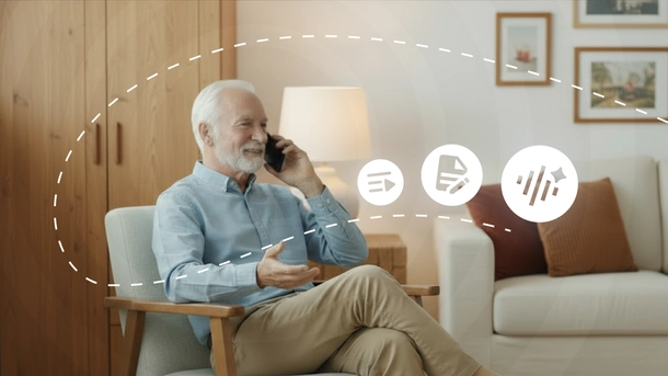 Un homme plus âgé, satisfait, est assis et parle au téléphone portable.